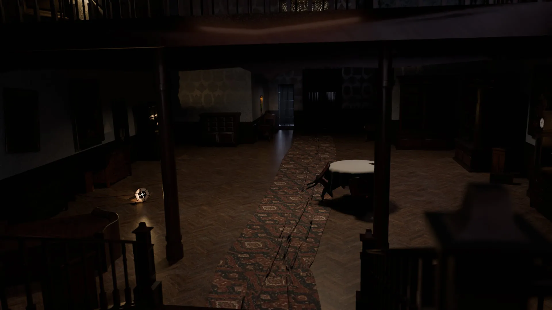 La salle à manger vue de la mezzanine, une table ronde et le chat dans l'ombre